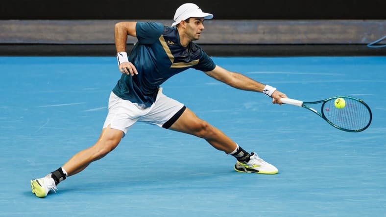 Jan 14, 2024; Melbourne, Victoria, Australia; Facundo Diaz Acosta of Argentina hits a shot against Taylor Fritz of the United States in the first round of the men s singles. Mandatory Credit: Mike Frey-USA TODAY Sports