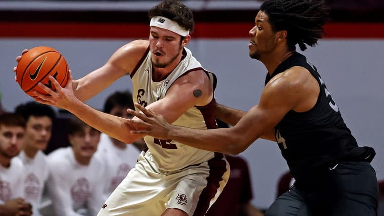 Jan 23, 2024; Blacksburg, Virginia, USA; Boston College Eagles forward Quinten Post (12) handles the ball against Virginia Tech Hokies forward Mylyjael Poteat (34) during the second half at Cassell Coliseum. Mandatory Credit: Peter Casey-USA TODAY Sports