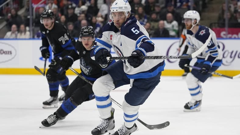 Jan 24, 2024; Toronto, Ontario, CAN; Winnipeg Jets defenseman Brenden Dillon (5) chases after a loose puck against the Toronto Maple Leafs during the third period at Scotiabank Arena. Mandatory Credit: John E. Sokolowski-USA TODAY Sports