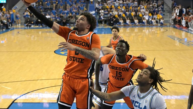 Feb 1, 2024; Los Angeles, California, USA; Oregon State Beavers guard Jordan Pope (0) scores past UCLA Bruins guard Brandon Williams (5) in the first half at Pauley Pavilion presented by Wescom. Mandatory Credit: Jayne Kamin-Oncea-USA TODAY Sports