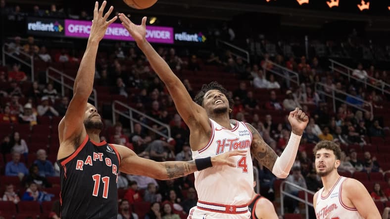 Feb 2, 2024; Houston, Texas, USA; Toronto Raptors forward Bruce Brown (11) and Houston Rockets guard Jalen Green (4) reach for a rebound in the first quarter at Toyota Center. Mandatory Credit: Thomas Shea-USA TODAY Sports