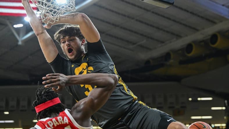 Feb 2, 2024; Iowa City, Iowa, USA; Iowa Hawkeyes forward Owen Freeman (32) completes a slam dunk over Ohio State Buckeyes center Felix Okpara (34) during the second half at Carver-Hawkeye Arena. Mandatory Credit: Jeffrey Becker-USA TODAY Sports
