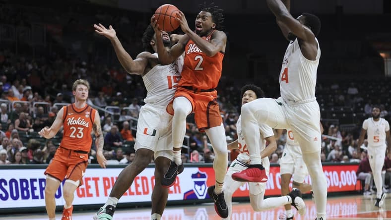 Feb 3, 2024; Coral Gables, Florida, USA; Virginia Tech Hokies guard MJ Collins (2) drives to the basket against Miami Hurricanes forward Norchad Omier (15) during the first half at Watsco Center. Mandatory Credit: Sam Navarro-USA TODAY Sports
