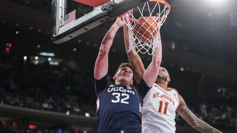 Feb 3, 2024; New York, New York, USA;  Connecticut Huskies center Donovan Clingan (32) dunks past St. John's Red Storm center Joel Soriano (11) in the first half at Madison Square Garden. Mandatory Credit: Wendell Cruz-USA TODAY Sports