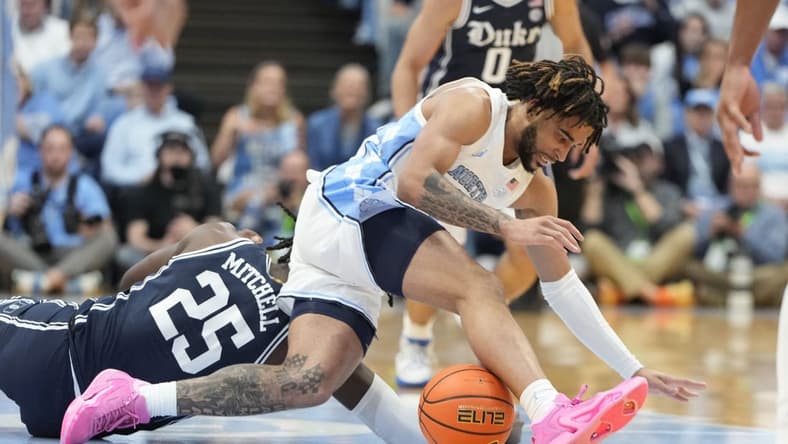 Feb 3, 2024; Chapel Hill, North Carolina, USA;  Duke Blue Devils forward Mark Mitchell (25) and North Carolina Tar Heels guard RJ Davis (4) fight for the ball in the first half at Dean E. Smith Center. Mandatory Credit: Bob Donnan-USA TODAY Sports
