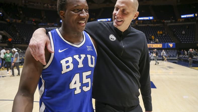 Feb 3, 2024; Morgantown, West Virginia, USA; Brigham Young Cougars head coach Mark Pope celebrates with Brigham Young Cougars forward Fousseyni Traore (45) after defeating the West Virginia Mountaineers at WVU Coliseum. Mandatory Credit: Ben Queen-USA TODAY Sports