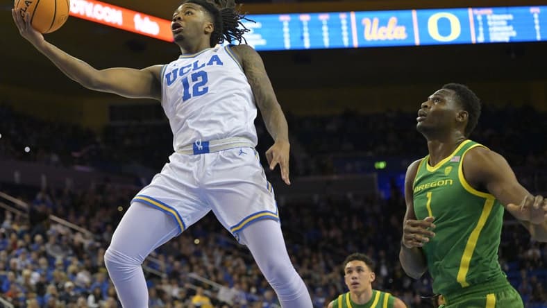 Feb 3, 2024; Los Angeles, California, USA; UCLA Bruins guard Sebastian Mack (12) drives past Oregon Ducks center N'Faly Dante (1) for a basket in the first half at Pauley Pavilion presented by Wescom. Mandatory Credit: Jayne Kamin-Oncea-USA TODAY Sports