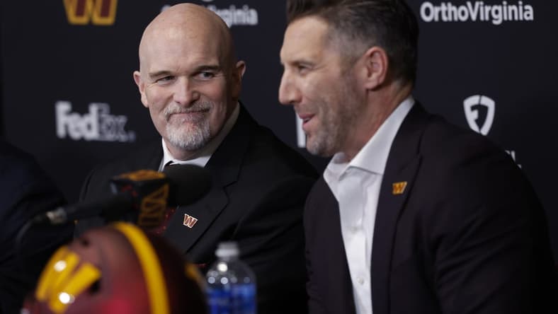Feb 5, 2024; Ashburn, VA, USA; Washington Commanders head coach Dan Quinn (L) smiles as Commanders general manager Adam Peters (R) speaks during Quinn's introductory press conference at Commanders Park. Mandatory Credit: Geoff Burke-USA TODAY Sports