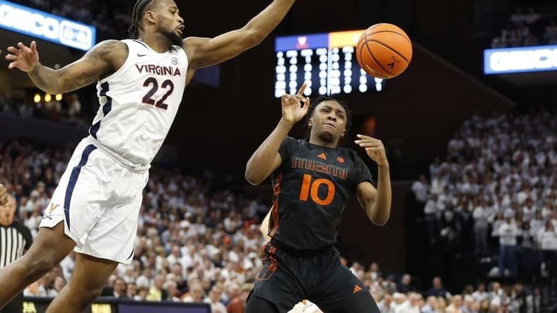 Feb 5, 2024; Charlottesville, Virginia, USA; Virginia Cavaliers forward Jordan Minor (22) knocks the ball away from Miami (Fl) Hurricanes guard Paul Djobet (10) during the first half at John Paul Jones Arena. Mandatory Credit: Amber Searls-USA TODAY Sports