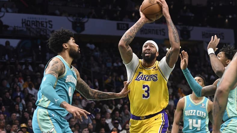 Feb 5, 2024; Charlotte, North Carolina, USA;  Los Angeles Lakers forward Anthony Davis (3) looks to pass as he is defended by Charlotte Hornets center Nick Richards (4) during the first half at the Spectrum Center. Mandatory Credit: Sam Sharpe-USA TODAY Sports
