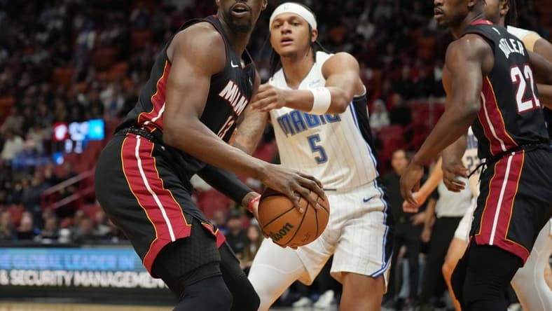 Feb 6, 2024; Miami, Florida, USA; Miami Heat center Bam Adebayo (13) looks to pass the ball as Orlando Magic forward Paolo Banchero (5) defends during the first half at Kaseya Center. Mandatory Credit: Jim Rassol-USA TODAY Sports