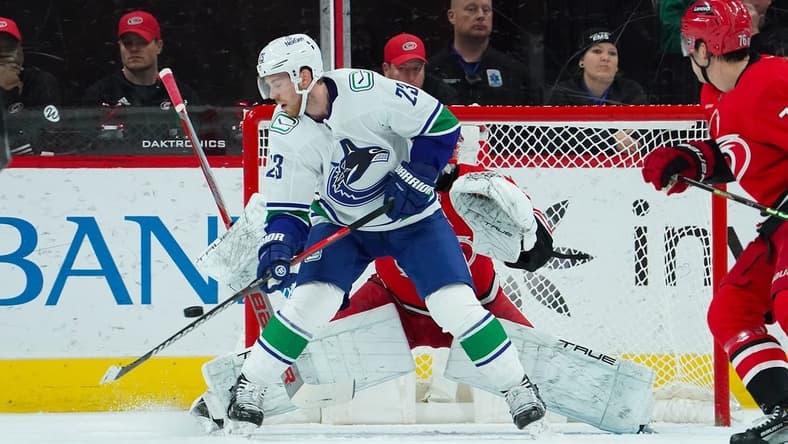 Feb 6, 2024; Raleigh, North Carolina, USA; Vancouver Canucks center Elias Lindholm (23) tips the puck past Carolina Hurricanes goaltender Pyotr Kochetkov (52) for a goal during the first period at PNC Arena. Mandatory Credit: James Guillory-USA TODAY Sports