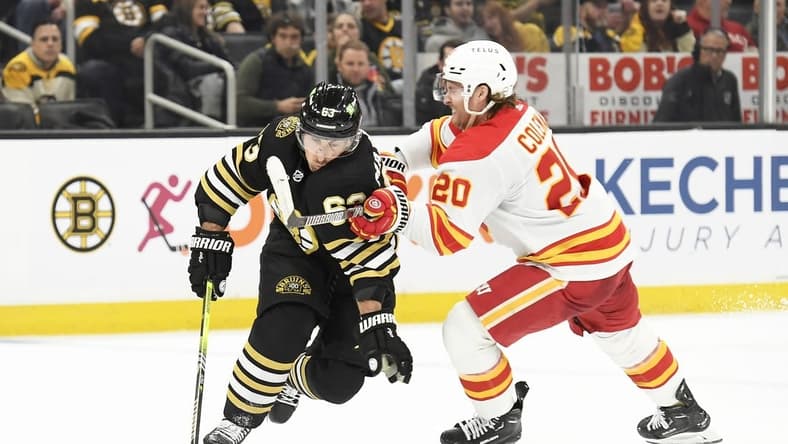 Feb 6, 2024; Boston, Massachusetts, USA; Boston Bruins left wing Brad Marchand (63) controls the puck from Calgary Flames center Blake Coleman (20) during the second period at TD Garden. Mandatory Credit: Bob DeChiara-USA TODAY Sports