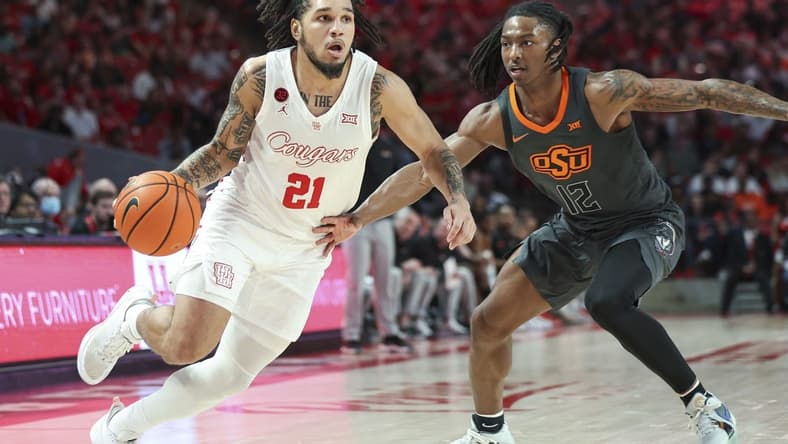 Feb 6, 2024; Houston, Texas, USA; Houston Cougars guard Emanuel Sharp (21) drives with the ball as Oklahoma State Cowboys guard Javon Small (12) defends during the second half at Fertitta Center. Mandatory Credit: Troy Taormina-USA TODAY Sports