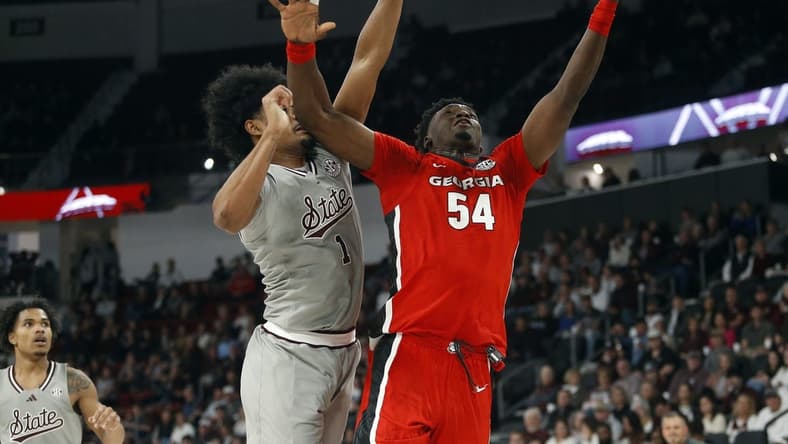 Feb 7, 2024; Starkville, Mississippi, USA; Georgia Bulldogs center Russel Tchewa (54) shoots as Mississippi State Bulldogs forward Tolu Smith (1) defends during the first half at Humphrey Coliseum. Mandatory Credit: Petre Thomas-USA TODAY Sports
