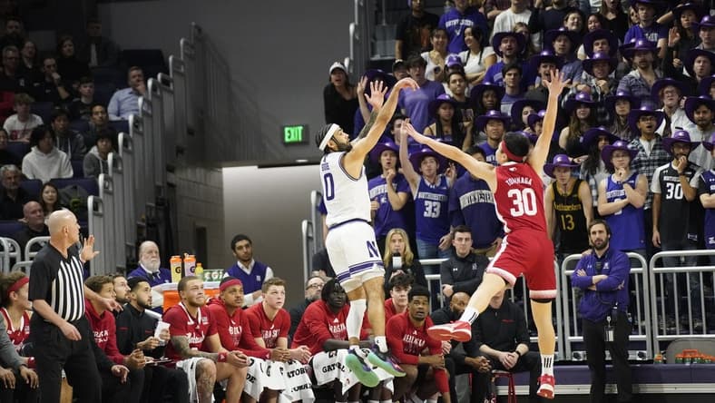 Feb 7, 2024; Evanston, Illinois, USA; Northwestern Wildcats guard Boo Buie (0) makes a three point basket over Nebraska Cornhuskers guard Keisei Tominaga (30)during the first half at Welsh-Ryan Arena. Mandatory Credit: David Banks-USA TODAY Sports