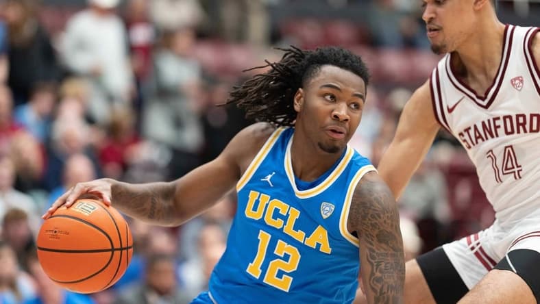 Feb 7, 2024; Stanford, California, USA; UCLA Bruins guard Sebastian Mack (12) controls the ball during the second half against Stanford Cardinal forward Spencer Jones (14) at Maples Pavilion. Mandatory Credit: Stan Szeto-USA TODAY Sports