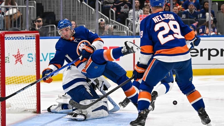 Feb 8, 2024; Elmont, New York, USA; New York Islanders center Kyle Palmieri (21) falls over Tampa Bay Lightning goaltender Jonas Johansson (31) during the second period at UBS Arena. Mandatory Credit: Dennis Schneidler-USA TODAY Sports