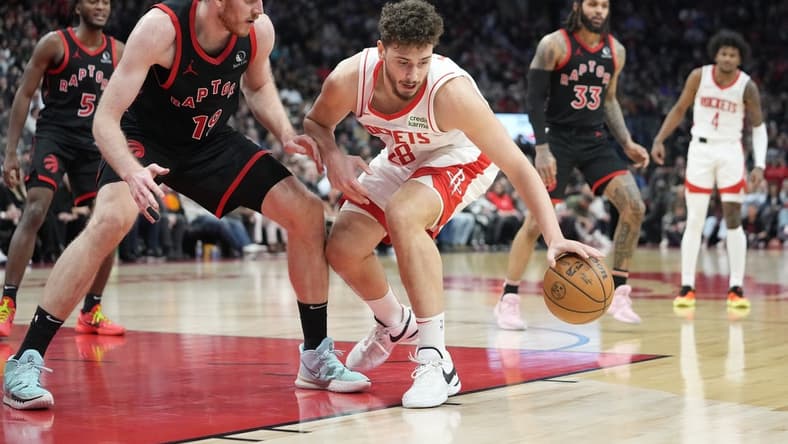 Feb 9, 2024; Toronto, Ontario, CAN; Houston Rockets center Alperen Sengun (28) controls the ball against Toronto Raptors center Jakob Poeltl (19) during the second half at Scotiabank Arena. Mandatory Credit: John E. Sokolowski-USA TODAY Sports