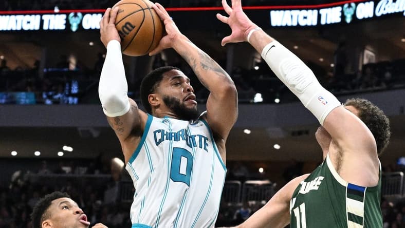Feb 9, 2024; Milwaukee, Wisconsin, USA; Charlotte Hornets forward Miles Bridges (0) drives to the basket against Milwaukee Bucks center Brook Lopez (11) in the first half at Fiserv Forum. Mandatory Credit: Michael McLoone-USA TODAY Sports