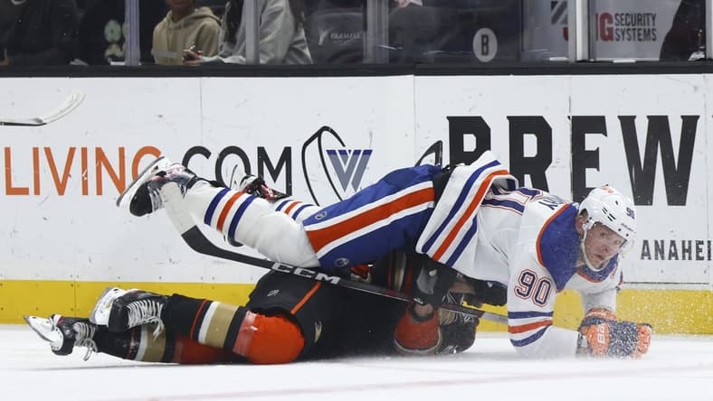 Feb 9, 2024; Anaheim, California, USA; Edmonton Oilers right wing Corey Perry (90) falls on top of an Anaheim Ducks player during the first period of a game at Honda Center. Mandatory Credit: Jessica Alcheh-USA TODAY Sports