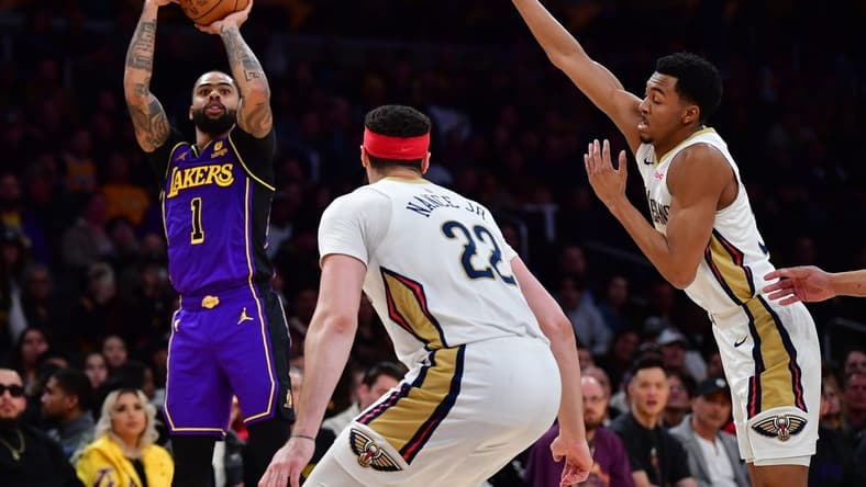 Feb 9, 2024; Los Angeles, California, USA; Los Angeles Lakers guard D'Angelo Russell (1) shoots against New Orleans Pelicans guard CJ McCollum (3) and forward Larry Nance Jr. (22) during the first half at Crypto.com Arena. Mandatory Credit: Gary A. Vasquez-USA TODAY Sports