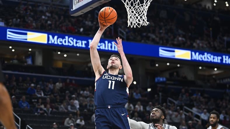 Feb 10, 2024; Washington, District of Columbia, USA; Connecticut Huskies forward Alex Karaban (11) shoots as Georgetown Hoyas guard Jay Heath (5) looks on during the first half at Capital One Arena. Mandatory Credit: Brad Mills-USA TODAY Sports