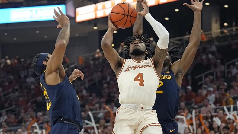 Feb 10, 2024; Austin, Texas, USA; Texas Longhorns guard Tyrese Hunter (4) shoots against West Virginia Mountaineers guards RaeQuan Battle (21) and Kobe Johnson (2) during the first half at Moody Center. Mandatory Credit: Scott Wachter-USA TODAY Sports
