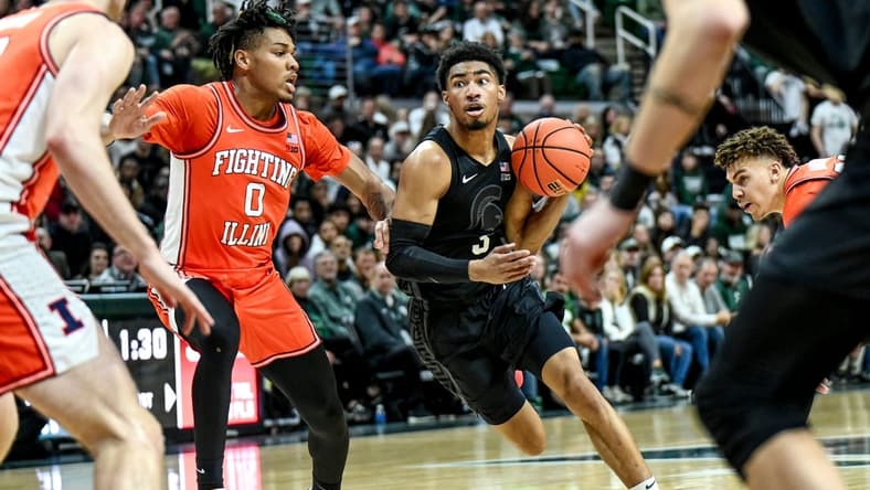 Michigan State's Jaden Akins, right, moves the ball as Illinois' Terrence Shannon Jr. defends during the first half on Saturday, Feb. 10, 2024, at the Breslin Center in East Lansing.
