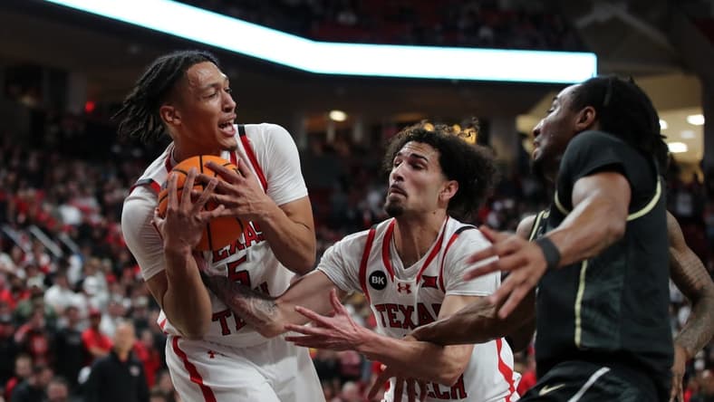 Feb 10, 2024; Lubbock, Texas, USA; Texas Tech Red Raiders guard Darrion Williams (5) grabs a rebound in front of guard Pop Isaacs (2) and Central Florida Knights guard Shaemarri Allen (2) in the first half United Supermarkets Arena. Mandatory Credit: Michael C. Johnson-USA TODAY Sports