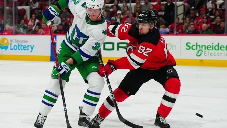 Feb 10, 2024; Raleigh, North Carolina, USA; Carolina Hurricanes right wing Andrei Svechnikov (37) and New Jersey Devils defenseman Santeri Hatakka (82) watch the shot during the second period at PNC Arena. Mandatory Credit: James Guillory-USA TODAY Sports