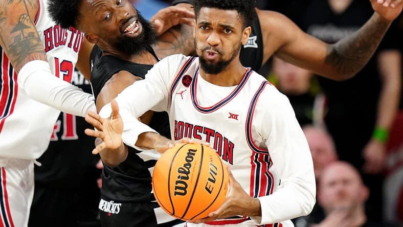 Cincinnati Bearcats forward John Newman III (15) reaches for a rebound against Houston Cougars guard Mylik Wilson (8) in the second half of an NCAA college basketball game between the Houston Cougars and the Cincinnati Bearcats, Saturday, Feb. 10, 2024, at Fifth Third Arena in Cincinnati.