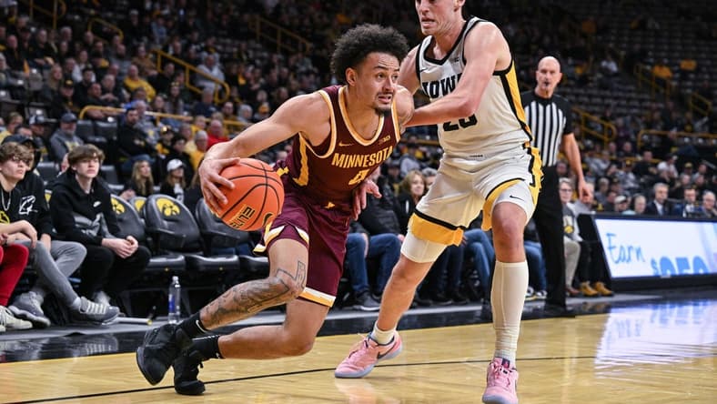 Feb 11, 2024; Iowa City, Iowa, USA; Minnesota Golden Gophers guard Braeden Carrington (4) goes to the basket as Iowa Hawkeyes forward Payton Sandfort (20) defends during the first half at Carver-Hawkeye Arena. Mandatory Credit: Jeffrey Becker-USA TODAY Sports