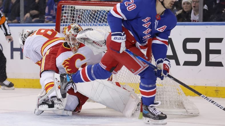 Feb 12, 2024; New York, New York, USA; Calgary Flames defenseman Chris Tanev (8) collides with goaltender Jacob Markstrom (25) as they fight for the puck against New York Rangers left wing Chris Kreider (20) during the first period at Madison Square Garden. Mandatory Credit: Brad Penner-USA TODAY Sports