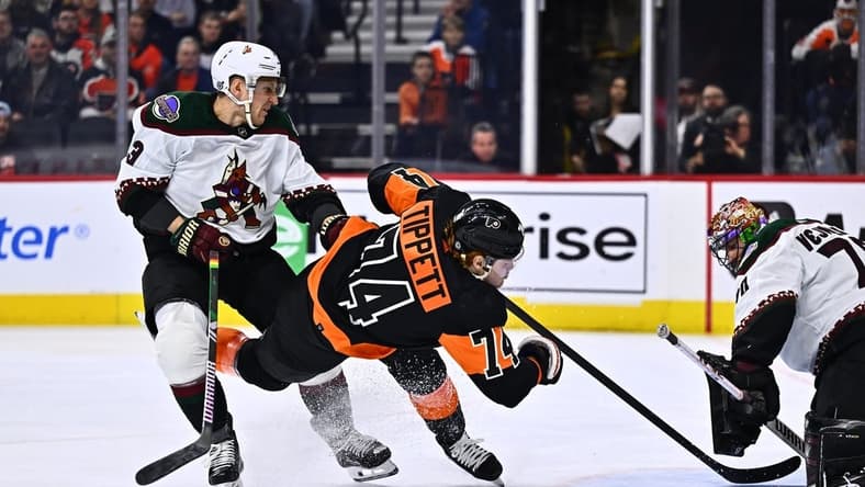 Feb 12, 2024; Philadelphia, Pennsylvania, USA; Philadelphia Flyers right wing Owen Tippett (74) falls after a hit from Arizona Coyotes defenseman Travis Dermott (33) in the first period at Wells Fargo Center. Mandatory Credit: Kyle Ross-USA TODAY Sports