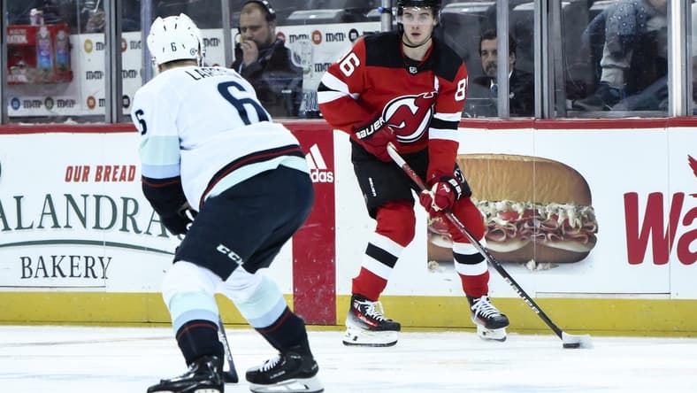 Feb 12, 2024; Newark, New Jersey, USA; New Jersey Devils center Jack Hughes (86) skates with the puck while being defended by Seattle Kraken defenseman Adam Larsson (6) during the second period at Prudential Center. Mandatory Credit: John Jones-USA TODAY Sports