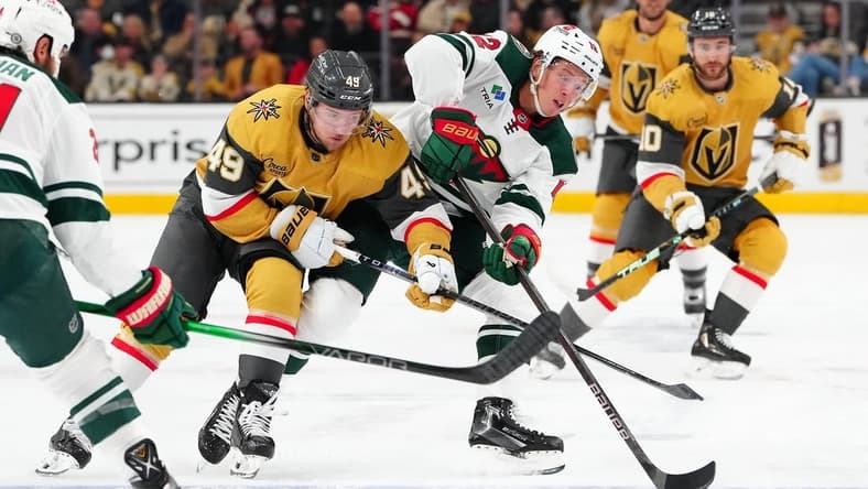 Feb 12, 2024; Las Vegas, Nevada, USA; Minnesota Wild left wing Matt Boldy (12) keeps the puck away from Vegas Golden Knights center Ivan Barbashev (49) during the first period at T-Mobile Arena. Mandatory Credit: Stephen R. Sylvanie-USA TODAY Sports