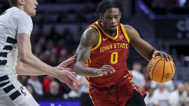 Feb 13, 2024; Cincinnati, Ohio, USA; Iowa State Cyclones forward Tre King (0) dribbles against Cincinnati Bearcats forward Viktor Lakhin (30) in the first half at Fifth Third Arena. Mandatory Credit: Katie Stratman-USA TODAY Sports