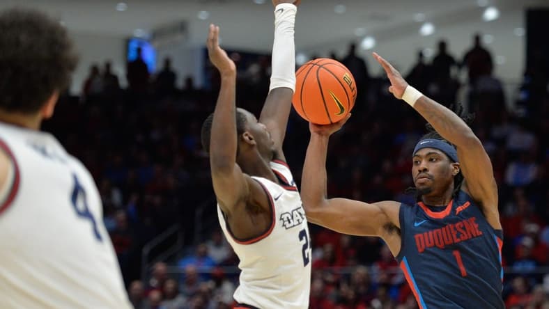 Feb 13, 2024; Dayton, Ohio, USA; Duquesne guard Jimmy Clark III (1) shoots the ball against Dayton Flyers guard Kobe Elvis (24) during the game at University of Dayton Arena. Mandatory Credit: Matt Lunsford-USA TODAY Sports