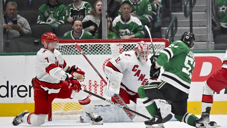 Feb 13, 2024; Dallas, Texas, USA; Carolina Hurricanes defenseman Dmitry Orlov (7) and goaltender Pyotr Kochetkov (52) face a shot by Dallas Stars center Wyatt Johnston (53) during the first period at the American Airlines Center. Mandatory Credit: Jerome Miron-USA TODAY Sports
