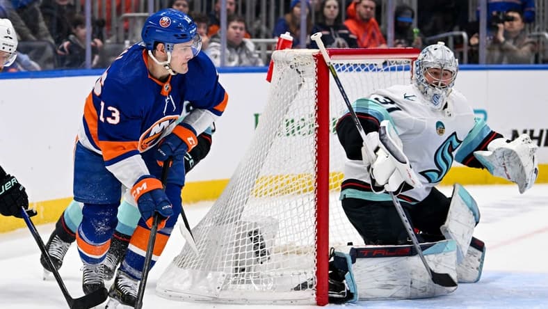 Feb 13, 2024; Elmont, New York, USA; New York Islanders center Mathew Barzal (13) attempts. A pass behind Seattle Kraken goaltender Philipp Grubauer (31) during the second period at UBS Arena. Mandatory Credit: Dennis Schneidler-USA TODAY Sports