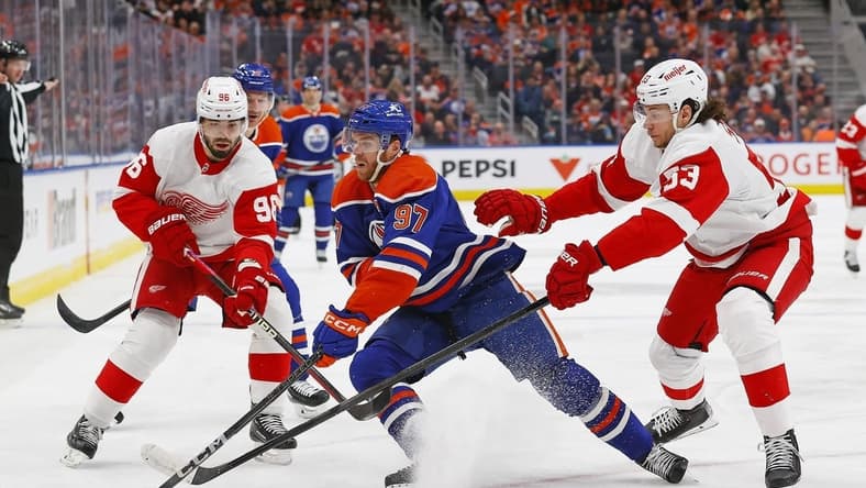 Feb 13, 2024; Edmonton, Alberta, CAN; Edmonton Oilers forward Connor McDavid (97) protects the puck from Detroit Red Wings defensemen Moritz Seider (53) and defensemen Jake Walman (96) at Rogers Place. Mandatory Credit: Perry Nelson-USA TODAY Sports