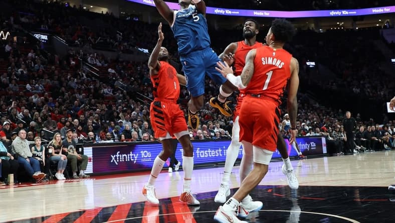 Feb 13, 2024; Portland, Oregon, USA; Minnesota Timberwolves guard Anthony Edwards (5) shoots the ball over Portland Trail Blazers forward Jerami Grant (9), center Deandre Ayton (2), and guard Anfernee Simons (1) in the second quarter at Moda Center. Mandatory Credit: Jaime Valdez-USA TODAY Sports