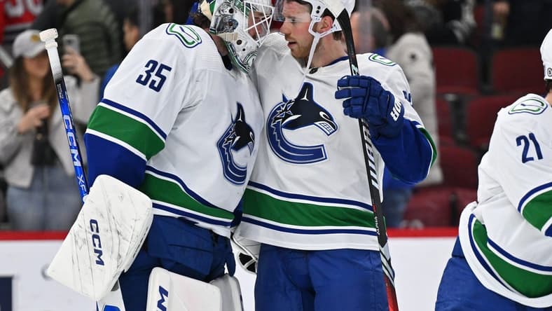 Feb 13, 2024; Chicago, Illinois, USA; Vancouver Canucks goaltender Thatcher Demko (35) and forward Elias Lindholm (23) celebrate after defeating the Chicago Blackhawks 4-2 at United Center. Mandatory Credit: Jamie Sabau-USA TODAY Sports