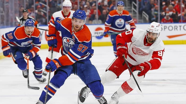 Feb 13, 2024; Edmonton, Alberta, CAN; Edmonton Oilers forward Connor McDavid (97) looks to make a pass in front of Detroit Red Wings forward Joe Veleno (90) during the third period at Rogers Place. Mandatory Credit: Perry Nelson-USA TODAY Sports