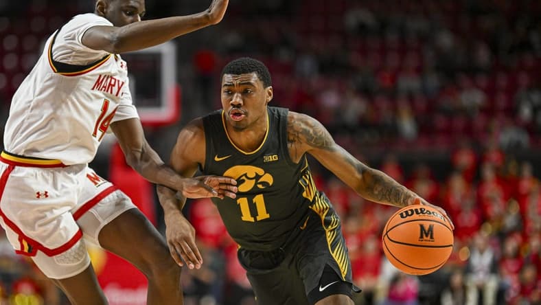 Feb 14, 2024; College Park, Maryland, USA; Iowa Hawkeyes guard Tony Perkins (11) drive to the basket on Maryland Terrapins forward Mady Traore (14) during the fist half at Xfinity Center. Mandatory Credit: Tommy Gilligan-USA TODAY Sports