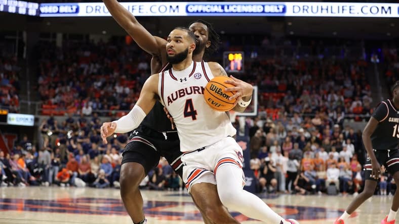 Feb 14, 2024; Auburn, Alabama, USA; Auburn Tigers forward Johni Broome (4) gets past South Carolina Gamecocks forward Josh Gray (33) for a shot during the second half at Neville Arena. Mandatory Credit: John Reed-USA TODAY Sports