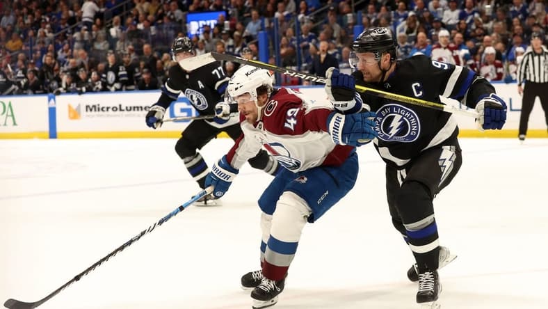Feb 15, 2024; Tampa, Florida, USA; Tampa Bay Lightning center Steven Stamkos (91) and Colorado Avalanche defenseman Samuel Girard (49) skate after the puck during the first period at Amalie Arena. Mandatory Credit: Kim Klement Neitzel-USA TODAY Sports