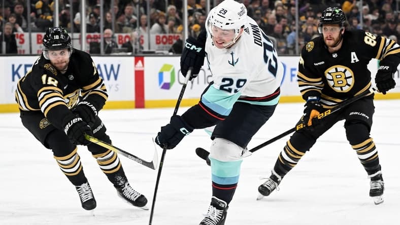 Feb 15, 2024; Boston, Massachusetts, USA; Seattle Kraken defenseman Vince Dunn (29) takes a shot in front of Boston Bruins center Pavel Zacha (18) during the second period at the TD Garden. Mandatory Credit: Brian Fluharty-USA TODAY Sports