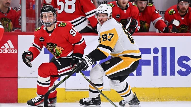 Feb 15, 2024; Chicago, Illinois, USA; Chicago Blackhawks forward Connor Bedard (98) and Pittsburgh Penguins forward Sidney Crosby (87) chase after a loose puck in the first period at United Center. Mandatory Credit: Jamie Sabau-USA TODAY Sports